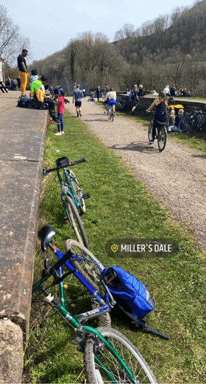 A flat grit cyclepath, busy with cyclists, in countryside surroundings on the Monsal Trail.
